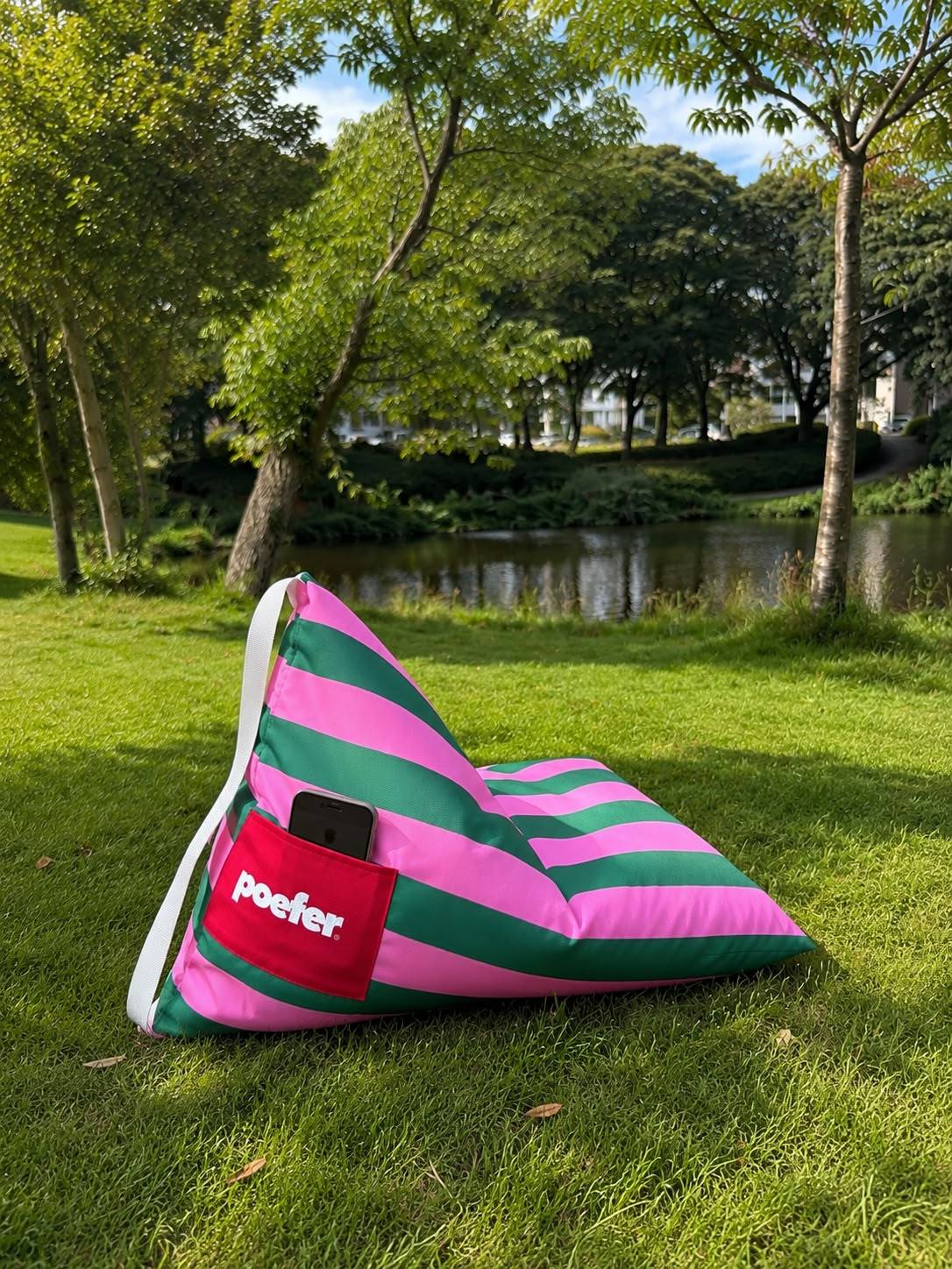 Poefer in het park, met telefoon in het zakje